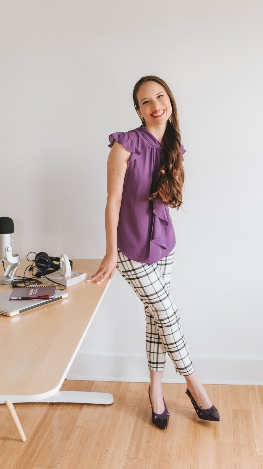 Meliss Jakubovic standing at her desk in a purple blouse